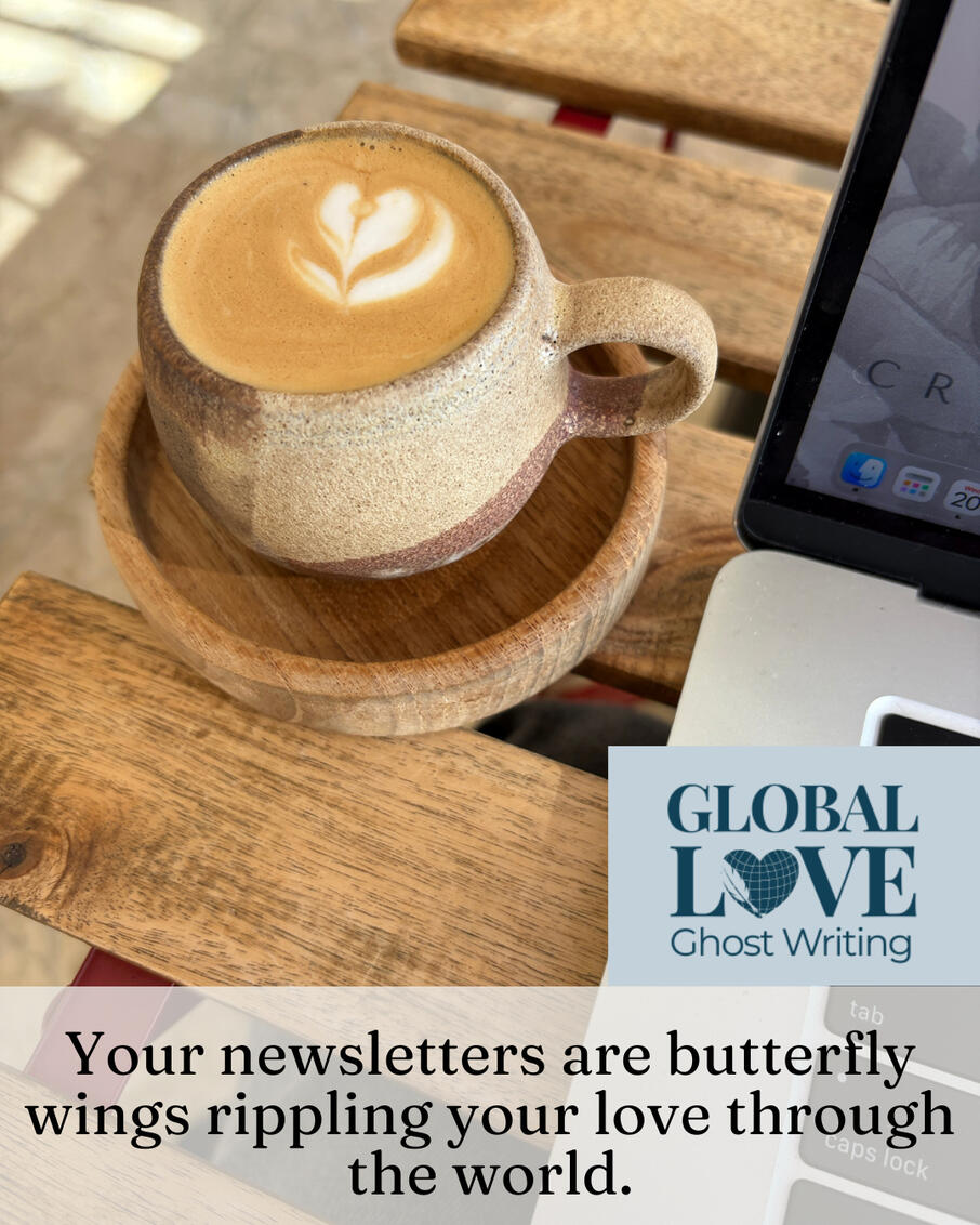 Coffee and Laptop in Tarifa Latte with heart foam art in a ceramic cup beside an open laptop on a wooden table, with the words "Your newsletter is butterfly wings rippling your love through the world."