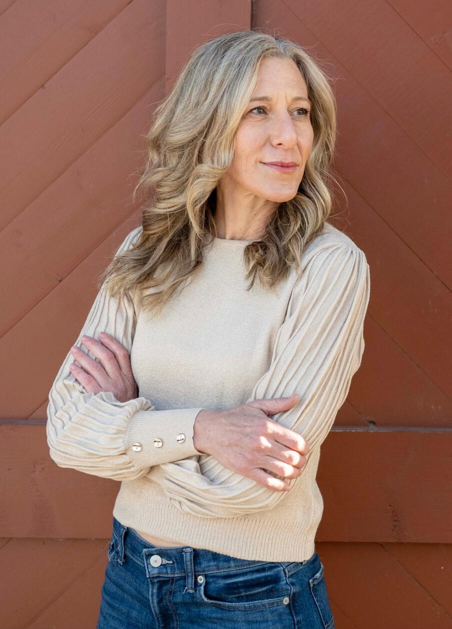 Global Love Writing Liz Brown Morgan Bio Picture Liz Brown Morgan, ghostwriter and founder of Global Love Writing, standing with arms crossed.